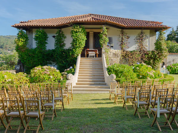 Finca con jardín y sillas preparadas para una ceremonia frente a la casa